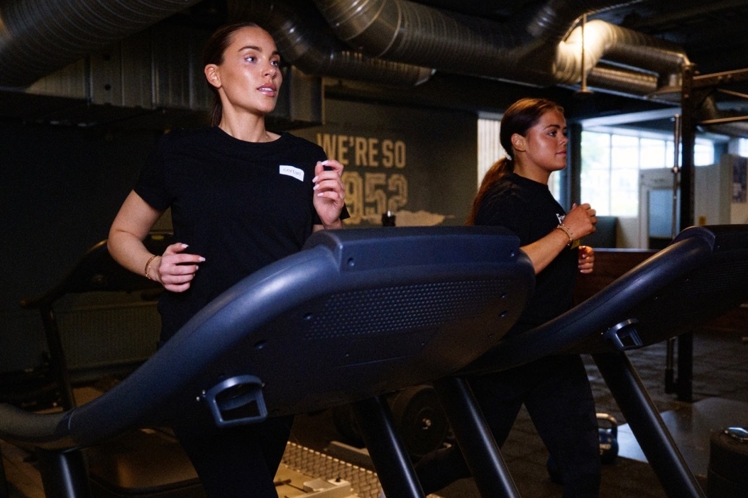 Två personer som löper på löpband