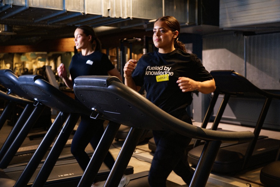 Två personer som springer på löpband intill varandra